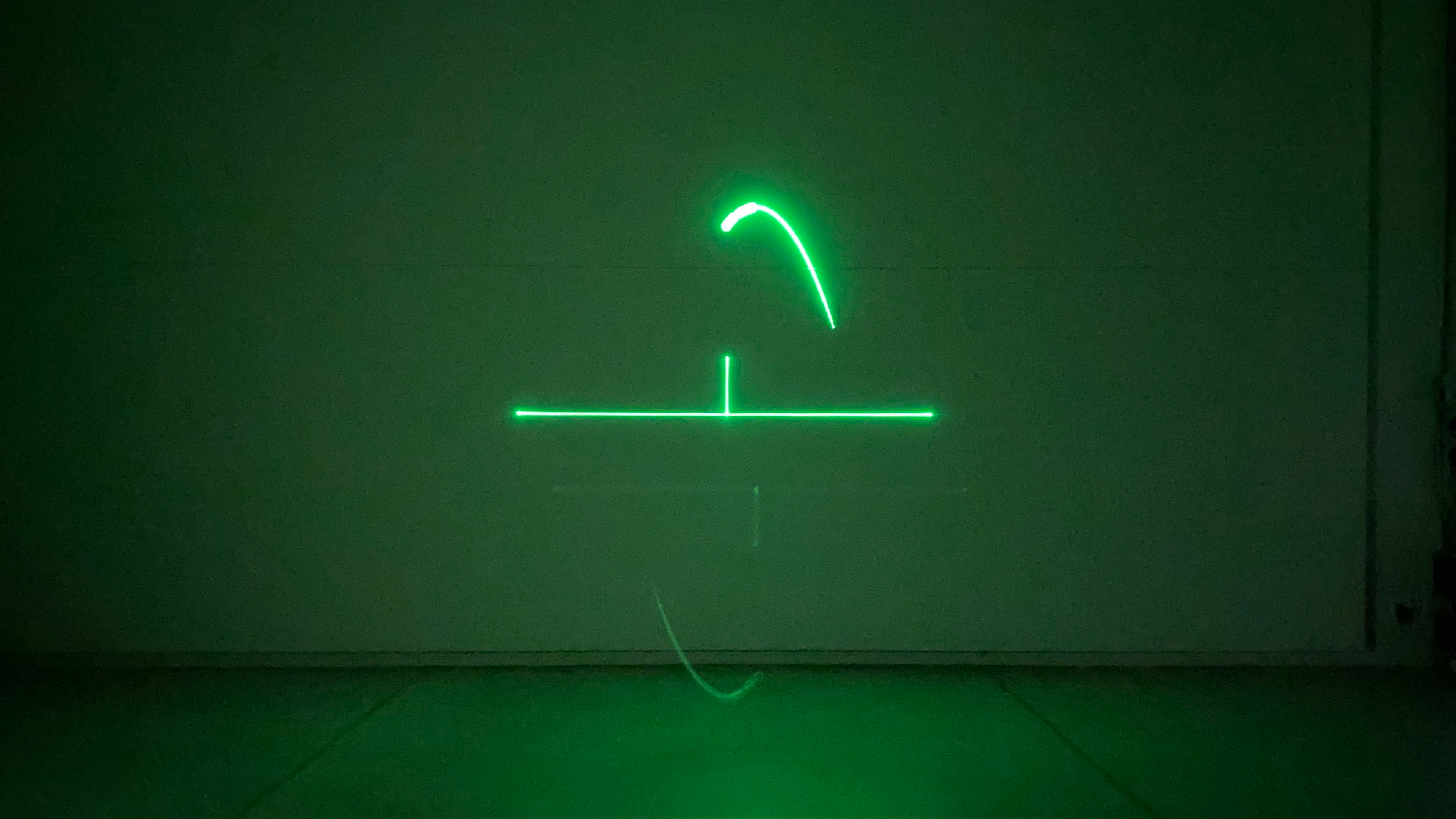 A laser projection onto a wall in a dark room. In green, tennis for two.